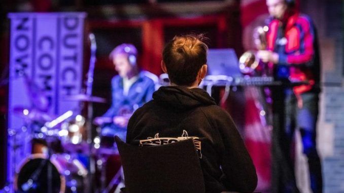 Con mascarilla y distancia social, un joven asiste a un concierto.