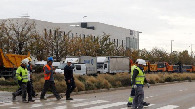 Varios operarios junto a las obras del Hospital de pandemias Isabel Zendal.