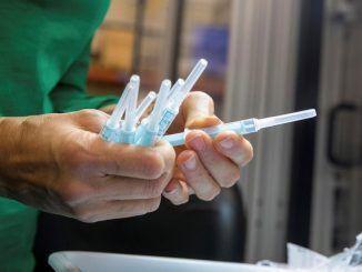 na operaria de la planta de la empresa Becton Dickinson de Fraga (Huesca) inspecciona unas muestras de la jeringuilla que fabrican para administrar la vacuna contra el coronavirus.