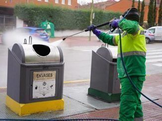 Operario desinfectando un contenedor de residuos en Móstoles