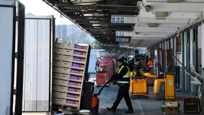 Descarga de los camiones repletos de frutas llegados a los hangares de Mercamadrid