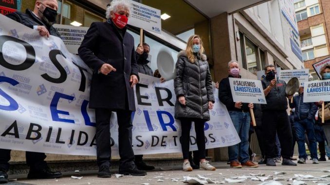 Un manifestante arroja un plato mientras miembros de la Asociación de Alojamiento Hostelería y Turismo de Segovia (HOTUSE-AIHS) se concentran este martes delante de la Subdelegación del Gobierno y la Delegación Territorial de la Junta de Castilla y León