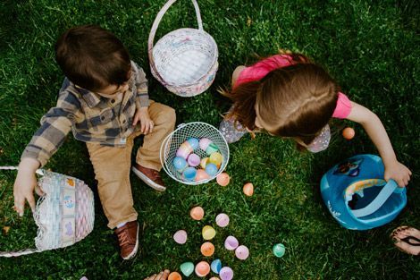 Dos niños juegan con huevos de Pascua en cestitas
