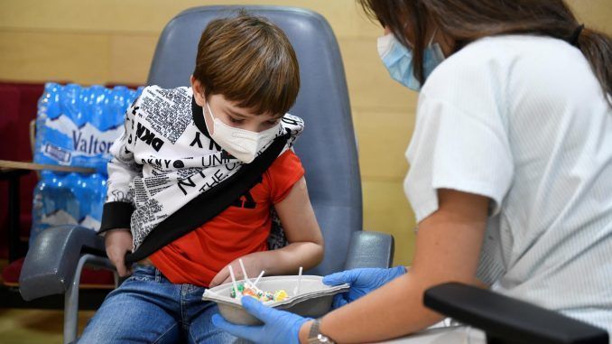 Una enfermera ofrece caramelos a un niño tras administrarle la vacuna contra la covid, en una imagen de archivo. EFE/Víctor Lerena
