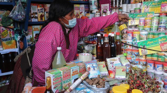 Una vendedora de plantas, flores y ungüentos naturales, conocidas como "chifleras", atiende su punto de venta, el 14 de febrero de 2022, en La Paz (Bolivia). EFE/Martin Alipaz
