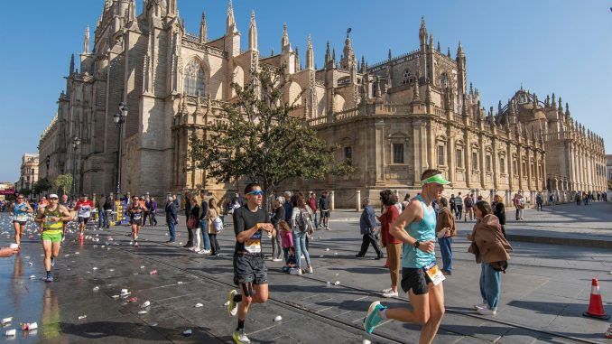 Participantes en la trigésima séptima edición del Maratón de Sevilla, a su paso por la Catedral hispalense. EFE/Raúl Caro
