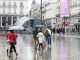 Varias personas se protegen de la lluvia con paraguas en la Puerta del Sol, en una fotografía de archivo. EFE/Víctor Casado