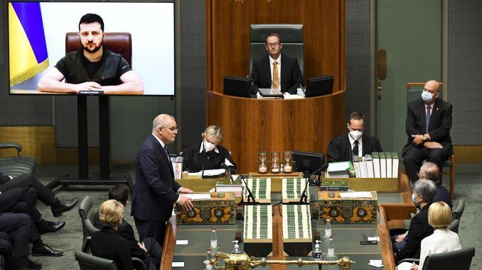 Un momento de la intervención por videoconferencia del presidente ucraniano, Volodimir Zelenski (en la pantalla) en el Parlamento australiano, en Canberra. EFE/EPA/LUKAS COCH
