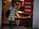 Una mujer espera frente a una tienda. EFE/Archivo