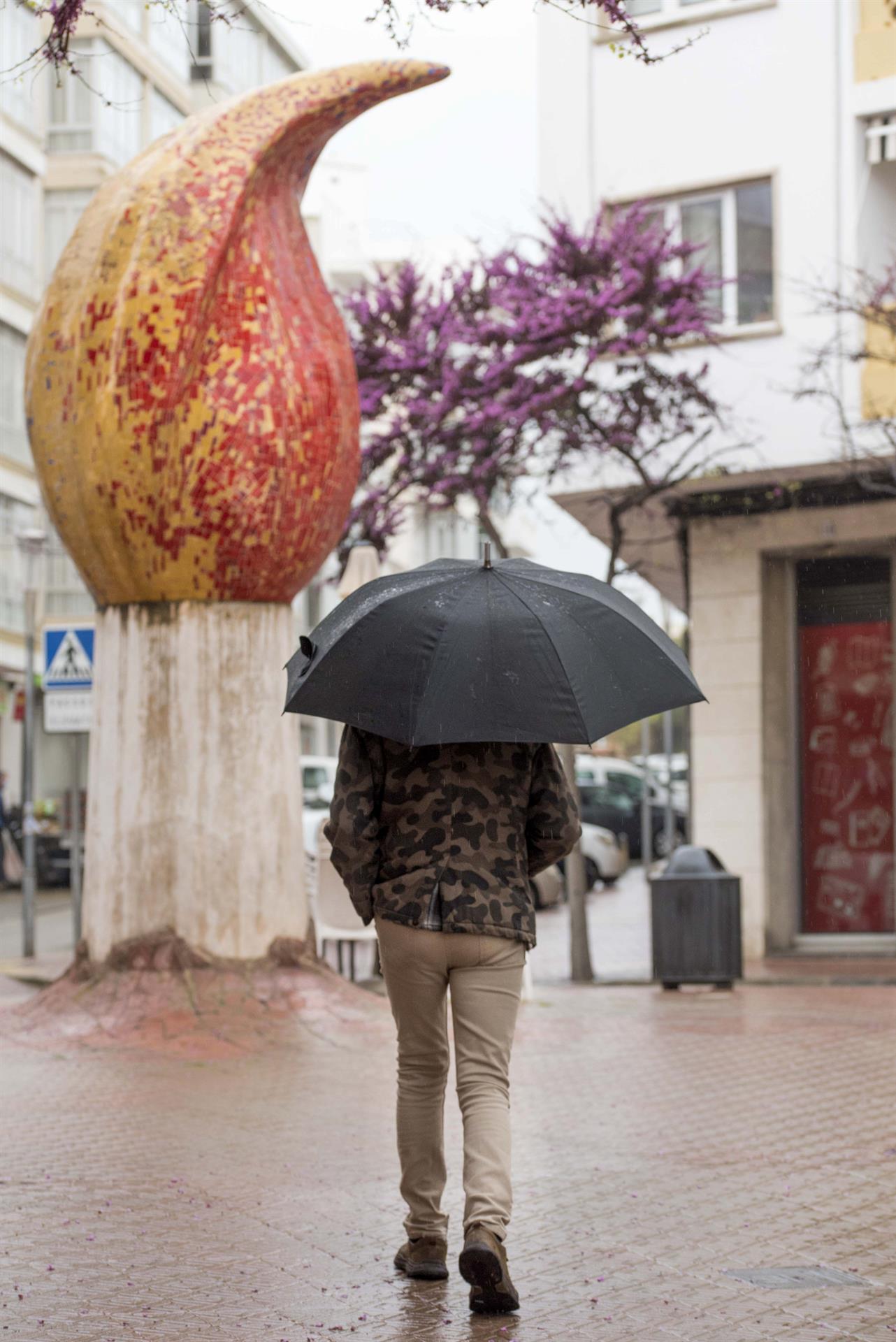 Un hombre camina bajo la lluvia por las calles de Mahón, Menorca este jueves. La entrada, en la segunda mitad del día, de un frente atlántico con una masa de aire frío del norte traerá descenso de temperaturas y precipitaciones que afectarán al Cantábrico, donde pueden ser localmente persistentes, y se moverán del noroeste hacia sudeste afectando además a Galicia, zonas de la Meseta, Andalucía y nordeste peninsular, según informa la Aemet. EFE/ David Arquimbau Sintes
