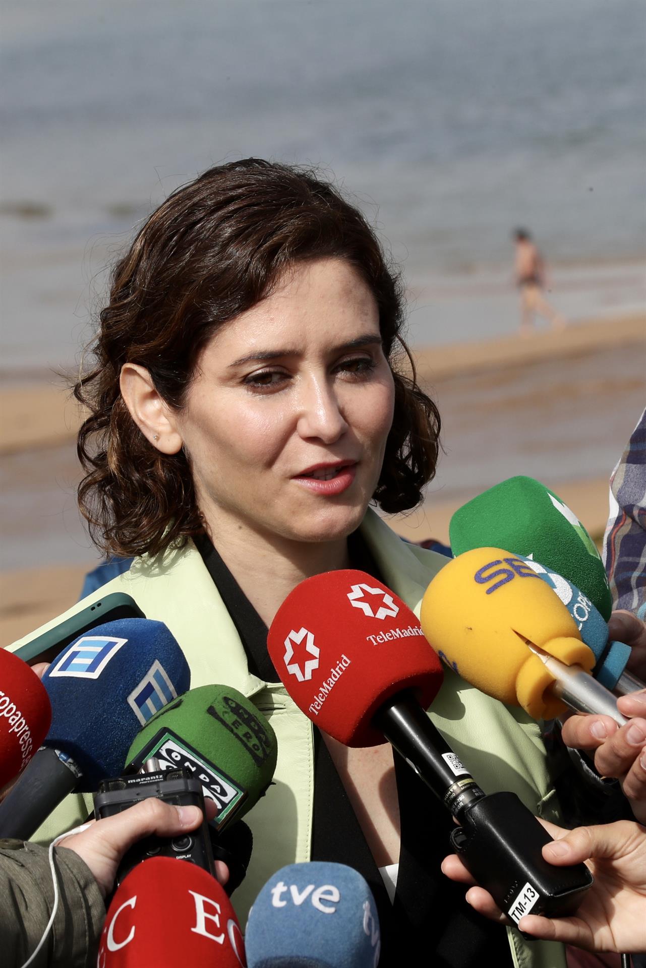 La presidenta de la Comunidad de Madrid, Isabel Díaz Ayuso (c) atiende a los medios de comunicación en el paseo de la bahía de Gijón antes de participar este viernes en un encuentro coloquio con empresarios y autónomos asturianos organizado por el PP de Asturias.EFE/J.L. Cereijido
