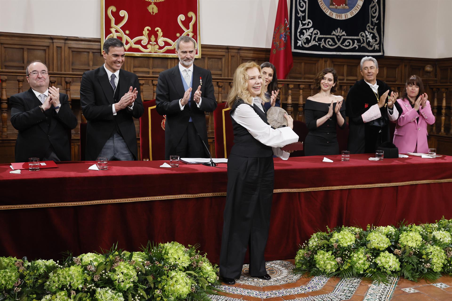 La actriz hispanoargentina Cecilia Roth (c) sonríe tras recoger el Premio Cervantes en nombre de la escritora uruguaya Cristina Peri Rossi de manos de los reyes Felipe VI (3i) y Letizia (4d), en presencia de el ministro de Cultura y Deporte, Miquel Iceta (i); el presidente del Gobierno español, Pedro Sánchez (2i); la presidenta de la Comunidad de Madrid, Isabel Díaz Ayuso, y el rector de la Universidad de Alcalá de Henares, José Vicente Saz (2d), durante la ceremonia de entrega del galardón este viernes en el Paraninfo de la Universidad de Alcalá de Henares. EFE/Ballesteros POOL
