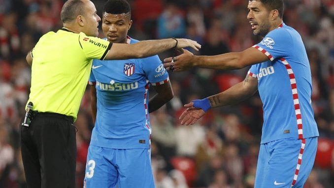 El árbitro conversa con los jugadores del Atlético de Madrid Luis Suárez (d) y Reinildo Mandava, durante el partido de Liga en Primera Divisiónen el estadio de San Mamés, en Bilbao. EFE/Miguel Toña
