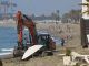 Una máquina trabaja para regenerar la arena de la playa de la Malagueta en Málaga. EFE/Álvaro Cabrera