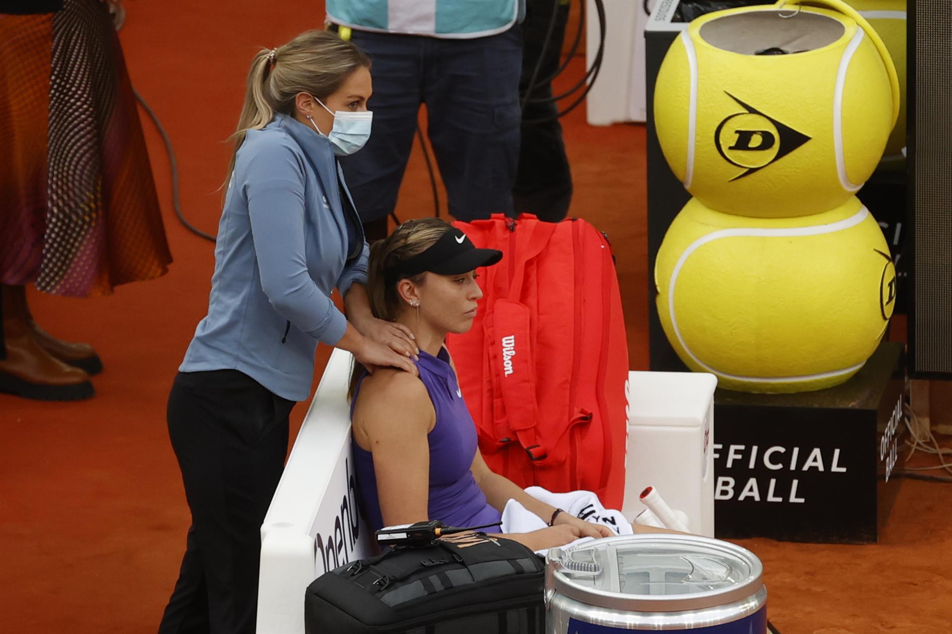 La tenista española Paula Badosa (d) es asistida por la fisioterapeuta, durante el partido de la segunda ronda del Mutua Madrid Open ante Simona Halep disputado en la Caja Mágica, en Madrid. EFE/Juanjo Martín

