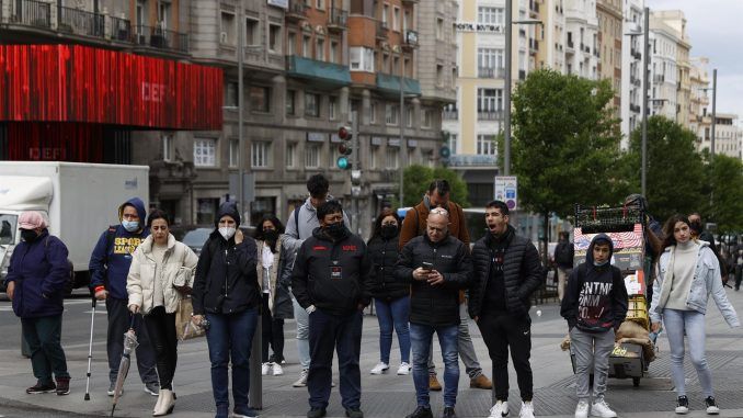 Varias personas esperan en un semáforo de la Gran Vía, este miércoles. El Boletín Oficial del Estado (BOE) publica este miércoles el real decreto por el que se elimina en España definitivamente la obligatoriedad de llevar mascarillas en interiores, salvo en el transporte público, centros sanitarios, residencias y farmacias. EFE/Mariscal
