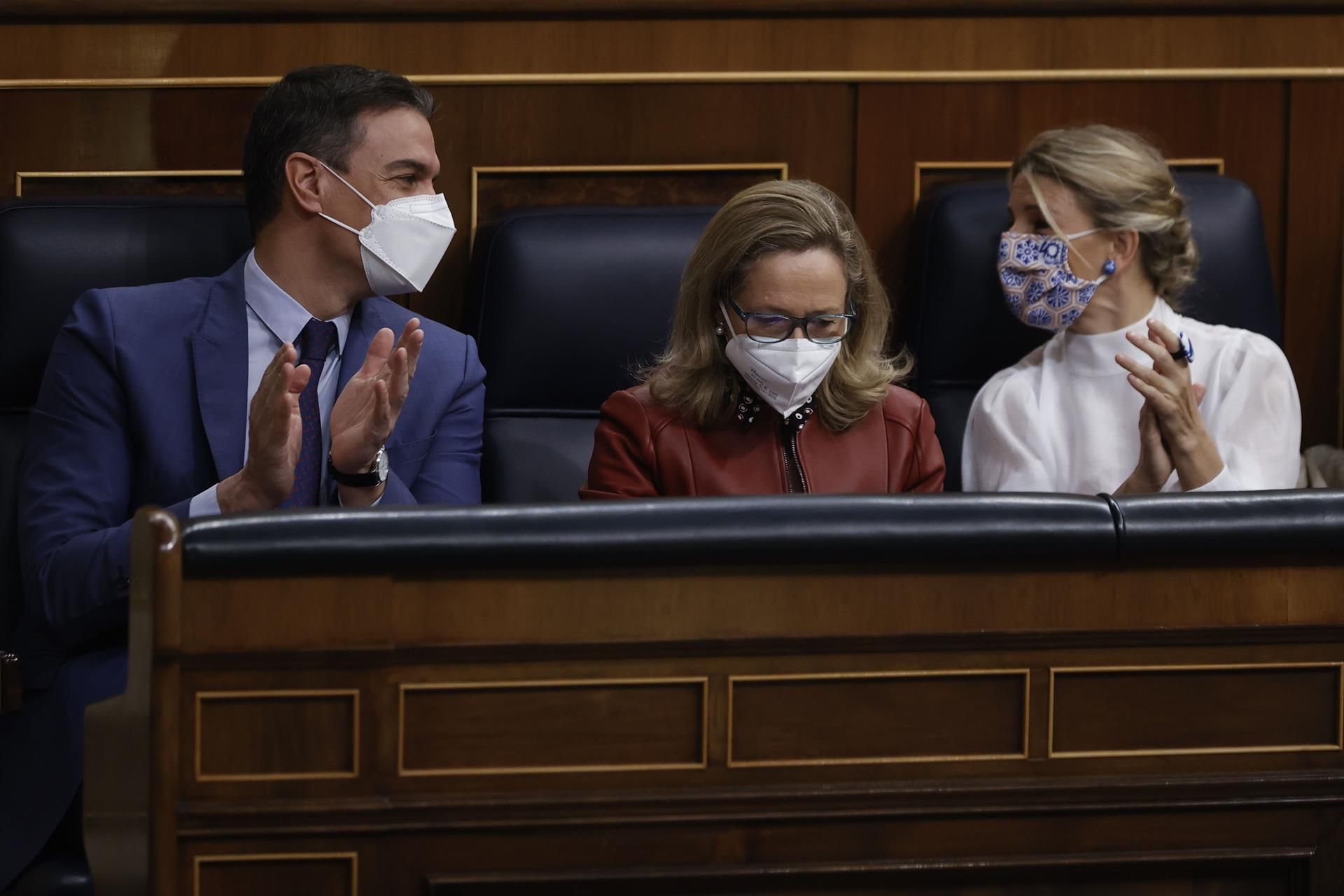 La vicepresidenta primera y ministra de Asuntos Económicos, Nadia Calviño (c), junto con el presidente del Gobierno, Pedro Sánchez (i) y la vicepresidenta segunda y ministra de Trabajo, Yolanda Díaz (d) durante la sesión de control al Gobierno, este miércoles, en el Congreso de los Diputados. EFE/Emilio Naranjo
