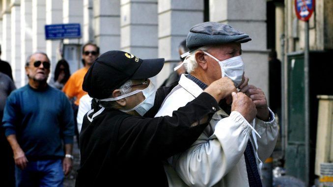 Dos personas se colocan mascarillas en una imagen de archivo. EFE/ALKIS KONSTANTINIDIS
