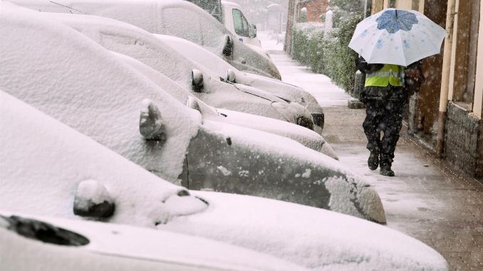 Un hombre se protege de la nieve en las calles de Ávila este miércoles. EFE/ Raúl Sanchidrián