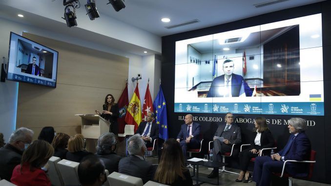 La periodista Verónica Sanz (i) modera el debate en el que participa el número dos de la Embajada de Ucrania en España, Dmytro Matiuschenko (por videoconferencia) durante un desayuno informativo en el Colegio de la Abogacía de Madrid este martes. EFE/ Javier Lizón
