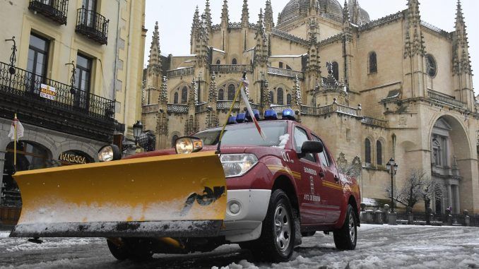 Un coche de bomberos con una pala quitanieves circula por las calles de Segovia que este miércoles han amanecido cubiertas de nieve. . EFE/ Pablo Martin
