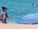 Dos jóvenes pasean con la mascarilla puesta por la orilla de la playa. EFE/Julián Pérez