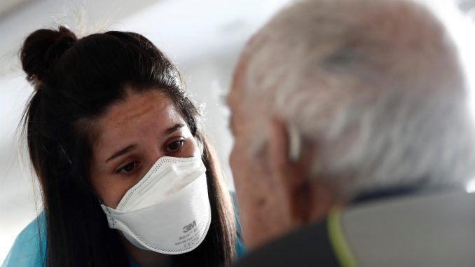 Una cuidadora atiende a un anciano en una residencia madrileña en una imagen de archivo. EFE/Mariscal
