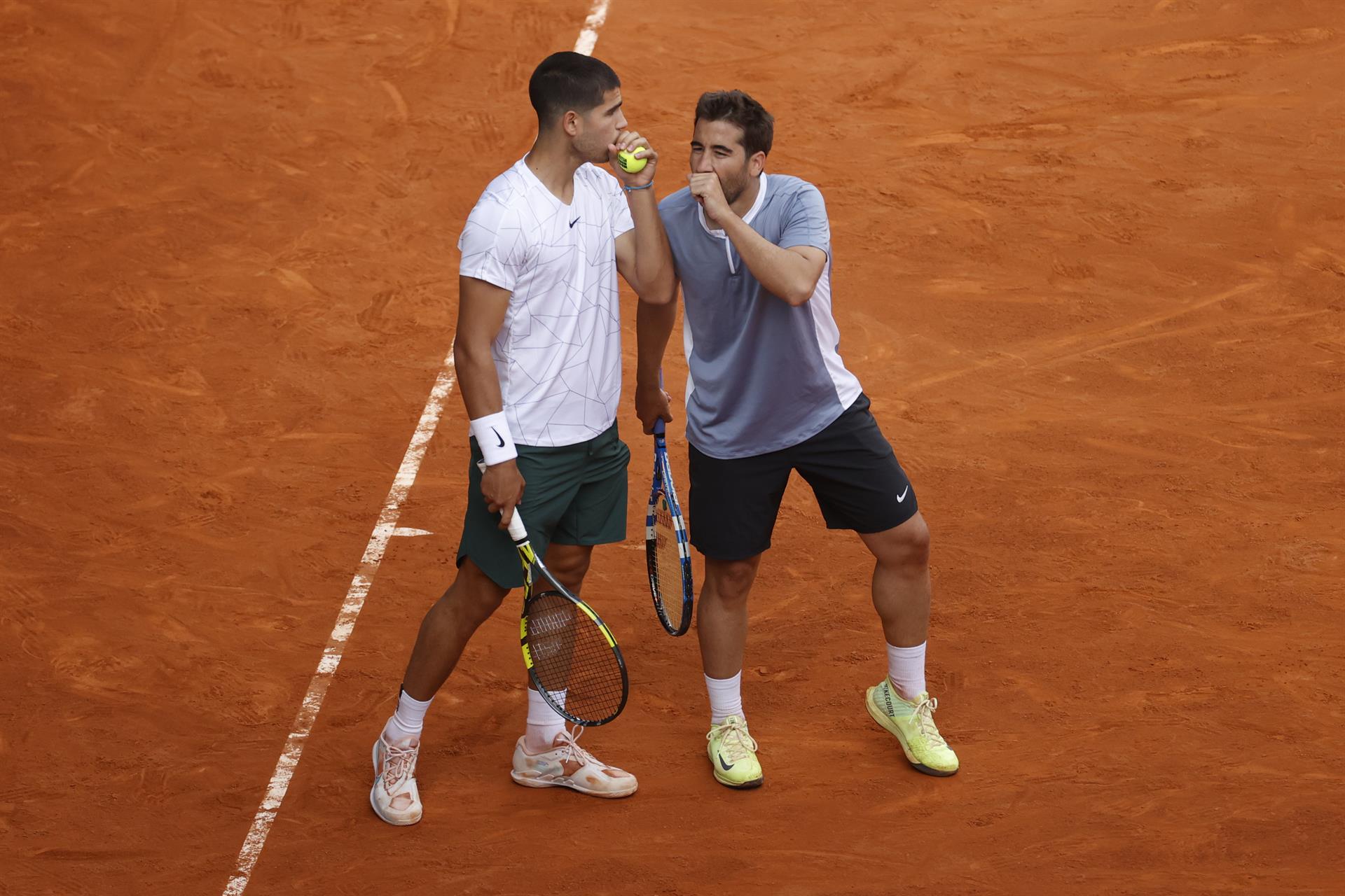 Los tenistas Carlos Alcaraz (i) y Marc López (d) durante su partido de dobles frente a la pareja formada por el polaco Lukasz Kubot y el francés Edouard Roger-Vasselin, en el Mutua Madrid Open disputado este domingo en la Caja Mágica, en Madrid. EFE/JUANJO MARTIN
