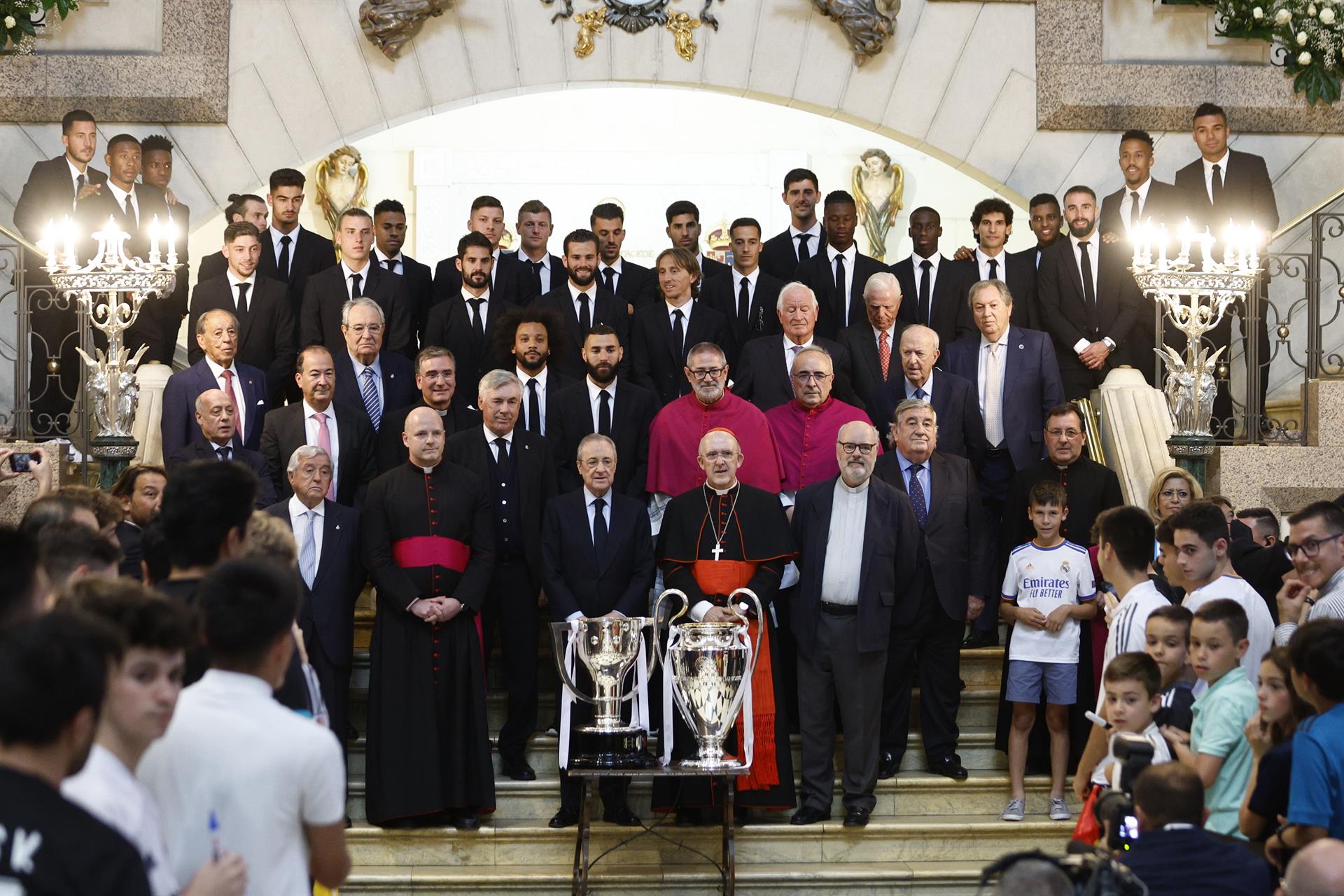 El presidente del Real Madrid, Florentino Pérez, junto al arzobispo de Madrid, Carlos Osoro, y miembros del cuerpo técnico y jugadores del equipo, posan para la foto de familia durante la ofrenda de los trofeos de LaLiga y la Liga de Campeones a la Virgen de la Almudena, patrona de Madrid, este domingo en la Catedral de la Almudena, una de las paradas del recorrido realizado esta tarde por el equipo para celebrar su victoria en la final de la Liga de Campeones. EFE/Rodrigo Jiménez
