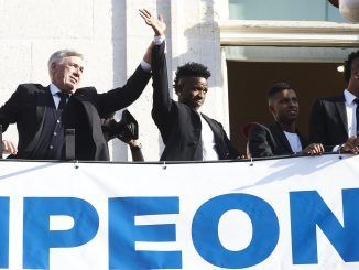 El entrenador del Real Madrid, Carlo Ancelotti (i), junto a Vinicius Jr. saluda desde la Real Casa de Correos, sede de la Comunidad de Madrid, una de las paradas del recorrido realizado este domingo por el equipo para celebrar su victoria en la final de la Liga de Campeones. EFE/Luca Piergiovanni