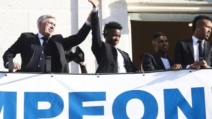 El entrenador del Real Madrid, Carlo Ancelotti (i), junto a Vinicius Jr. saluda desde la Real Casa de Correos, sede de la Comunidad de Madrid, una de las paradas del recorrido realizado este domingo por el equipo para celebrar su victoria en la final de la Liga de Campeones. EFE/Luca Piergiovanni
