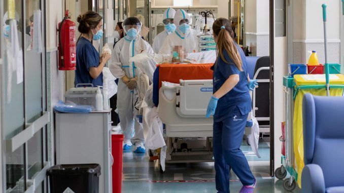 Varios sanitarios trasladan a un paciente en el pasillo de un hospital. EFE/Marcial Guillén/Archivo
