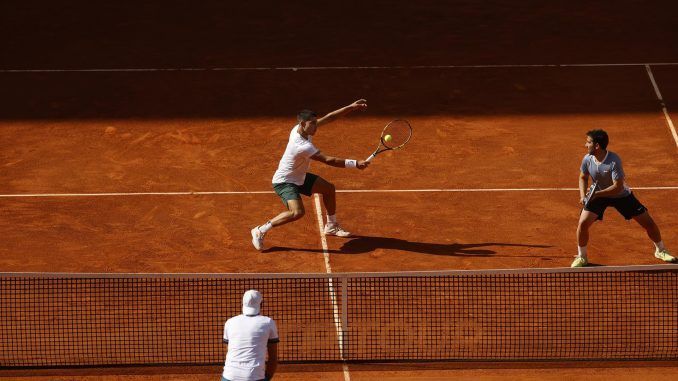 Los tenistas Carlos Alcaraz (i) y Marc López (d) durante su partido de dobles frente a la pareja formada por el polaco Lukasz Kubot y el francés Edouard Roger-Vasselin, en el Mutua Madrid Open disputado este domingo en la Caja Mágica, en Madrid. EFE/JUANJO MARTIN
