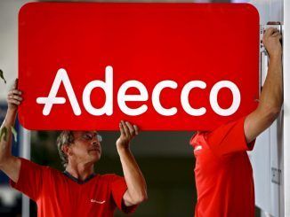 Dos trabajadores que instalan un cartel con el logo de la empresa de contratación temporal Adecco, en una fotografía de archivo. EFE/Laurent Gillieron