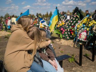 Dos mujeres se abrazan junto a la tumba de su familiar muerto en un cementerio, hoy domingo 1 de mayo del 2022 en Horodyshche (Ucrania). Los ucranianos celebran el domingo posterior a la Pascua Ortodoxa su día de muertos, y por eso hoy los cementerios del país se han llenado de familias que visitaban sus tumbas con flores y dulces, como manda la tradición, y no han sido pocas las que han tenido que recordar a sus soldados muertos en la guerra. EFE/Miguel Gutiérrez