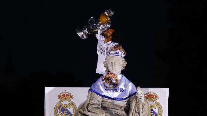 El capitán del Real Madrid Marcelo Vieira levanta la copa tras poner una bufanda a la diosa Cibeles durante la celebración con los aficionados de la victoria del equipo en la final de la Liga de Campeones. EFE/Sergio Pérez
