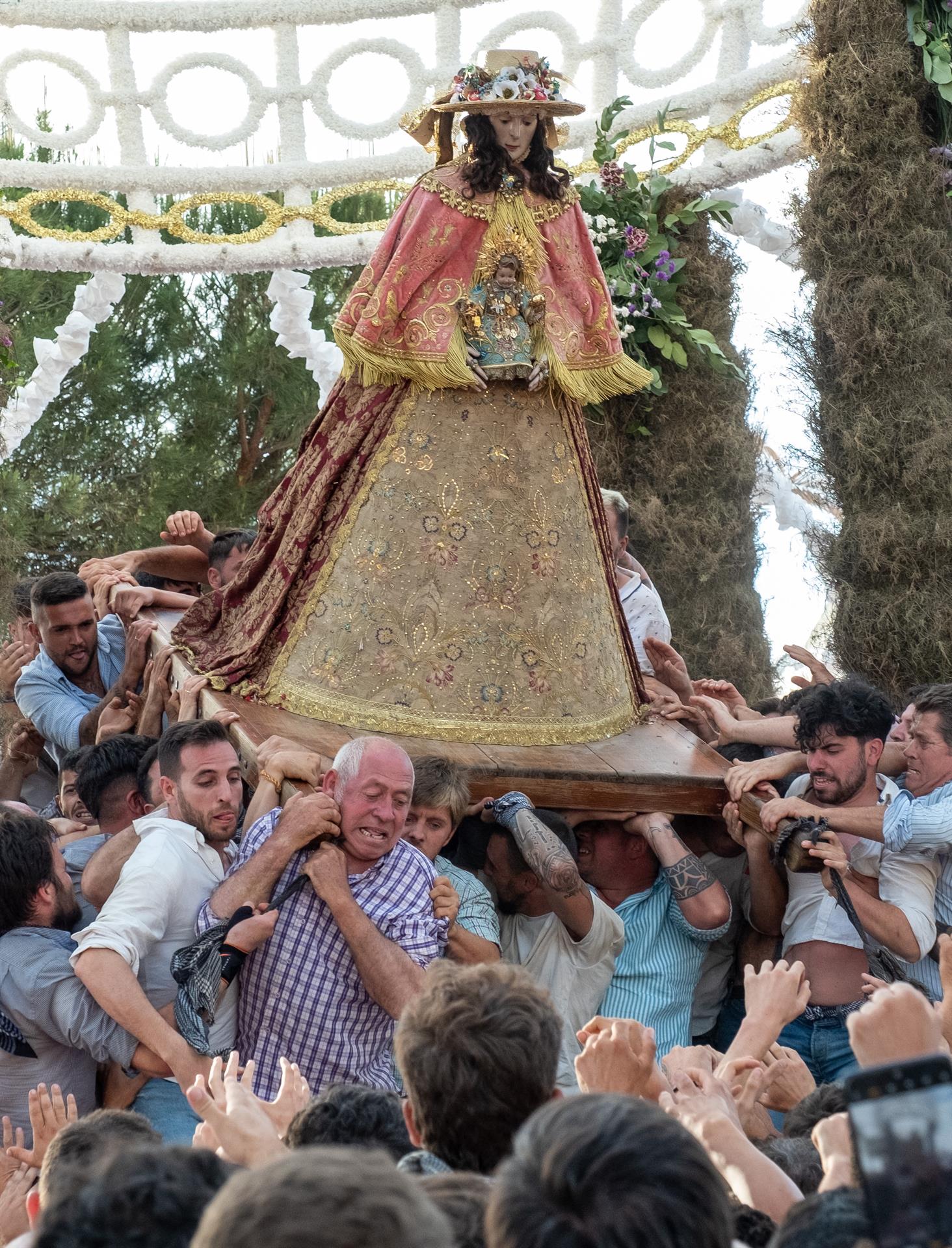 Los almonteños portan a hombros a la Virgen del Rocío durante el traslado de la imagen hoy domingo a la aldea almonteña de El Rocío tras permanecer en Almonte durante 33 meses. EFE/Julián Pérez
