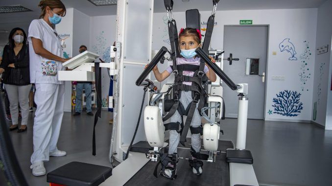 Valeria, paciente del hospital, utiliza este martes el robot Lokomat en su terapia durante la presentación del sistema robótico "Lokomat infantil" donado por la Fundación Aladina al Hospital Nacional de Parapléjicos de Toledo. EFE/Ismael Herrero
