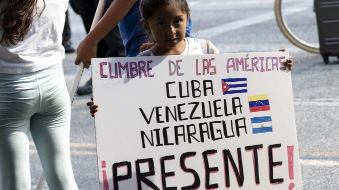 Una niña sostiene un cartel durante una protesta frente al teatro Microsoft, donde se realiza la ceremonia de inauguración de la IX Cumbre de las Américas, en Los Ángeles, California (EE.UU.), este 8 de junio de 2022. EFE/EPA/Etienne Laurent
