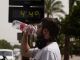 Un joven bebe agua junto a un termómetro de calle que marca 44º en el centro de Córdoba. EFE/Archivo