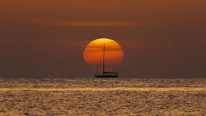 Un barco navega al amanecer frente a la playa de Las Rotas de Denia (Alicante) , hoy viernes.EFE/Biel Aliño
