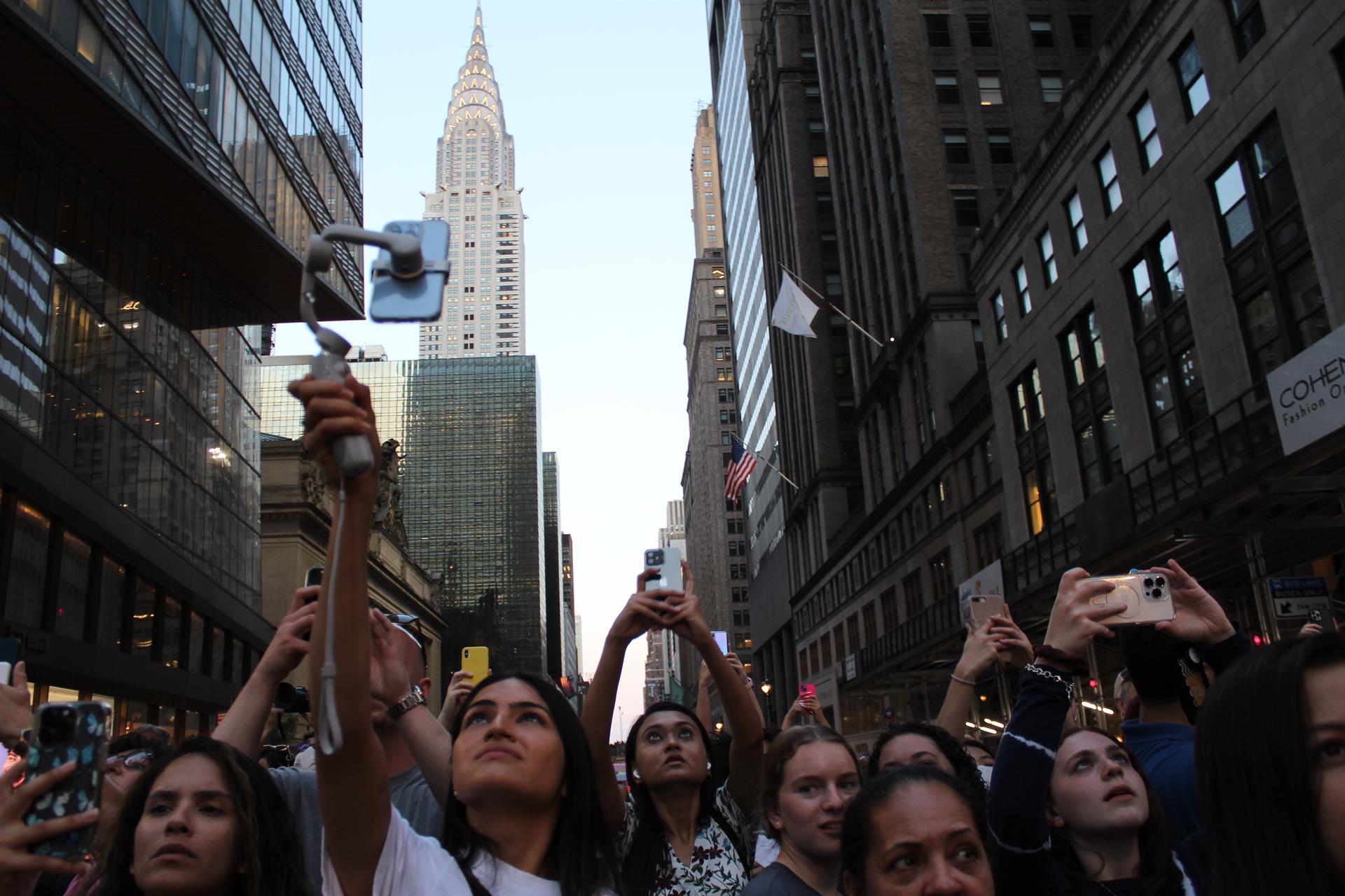 Un grupo de personas toman fotografías a la puesta del sol entre edificios hoy, en una calle de Manhattan en Nueva York (EE.UU.). EFE/ Sarah Yáñez-Richards
