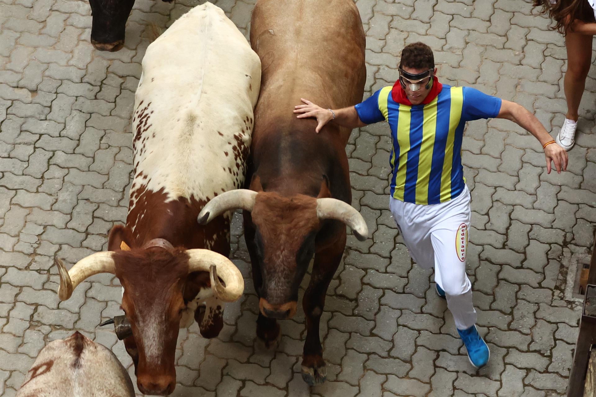 Los mozos, durante el octavo y último encierro de los Sanfermines con toros de la ganadería de Miura en el tramo final de entrada a la Plaza de Toros de Pamplona. este jueves. EFE/J.P. Urdiroz
