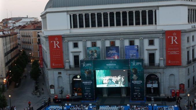 Cientos de personas asisten a la gran retransmisión de Nabucco en pantalla gigante en el exterior del Teatro Real, este jueves. EFE/ Juanjo Martín
