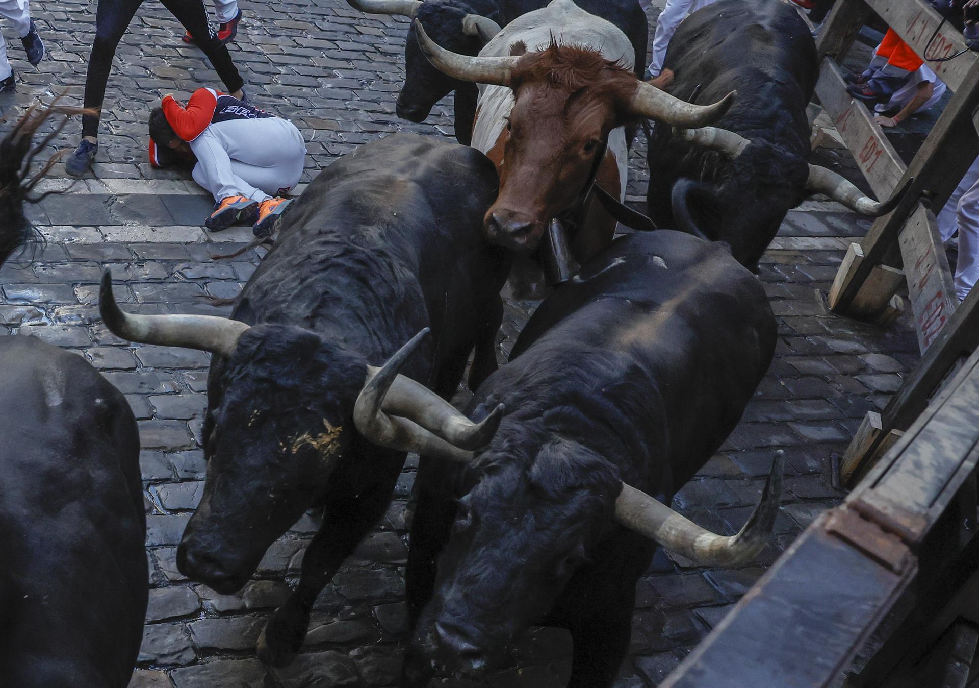 Los de la ganadería gaditana de Fuente Ymbro llegan a la curva de Mercaderes durante el segundo encierro de los Sanfermines 2022. EFE/Villar López
