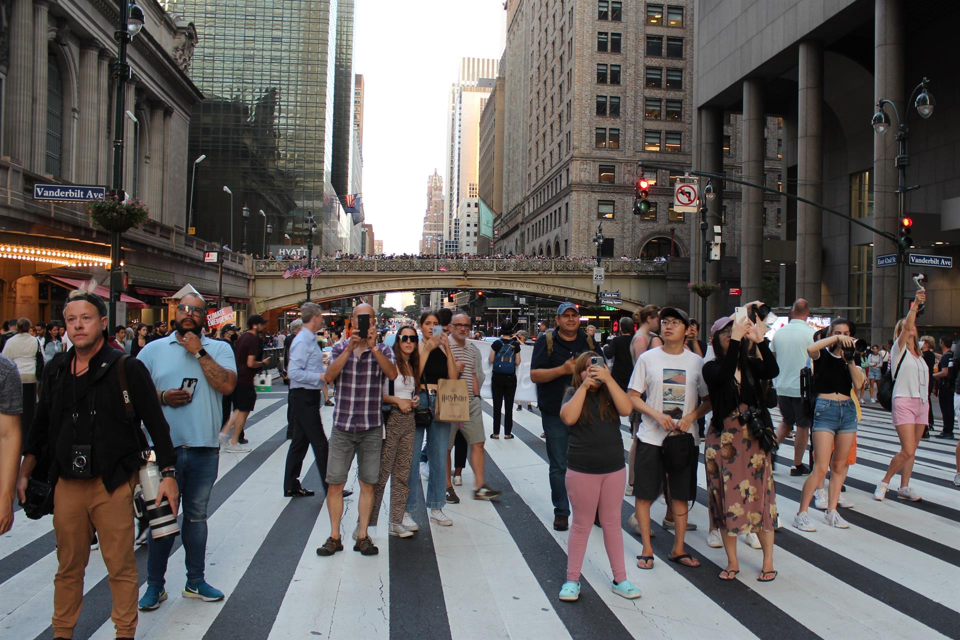 Un grupo de personas toman fotografías a la puesta del sol entre edificios hoy, en una calle de Manhattan en Nueva York (EE.UU.). EFE/ Sarah Yáñez-Richards
