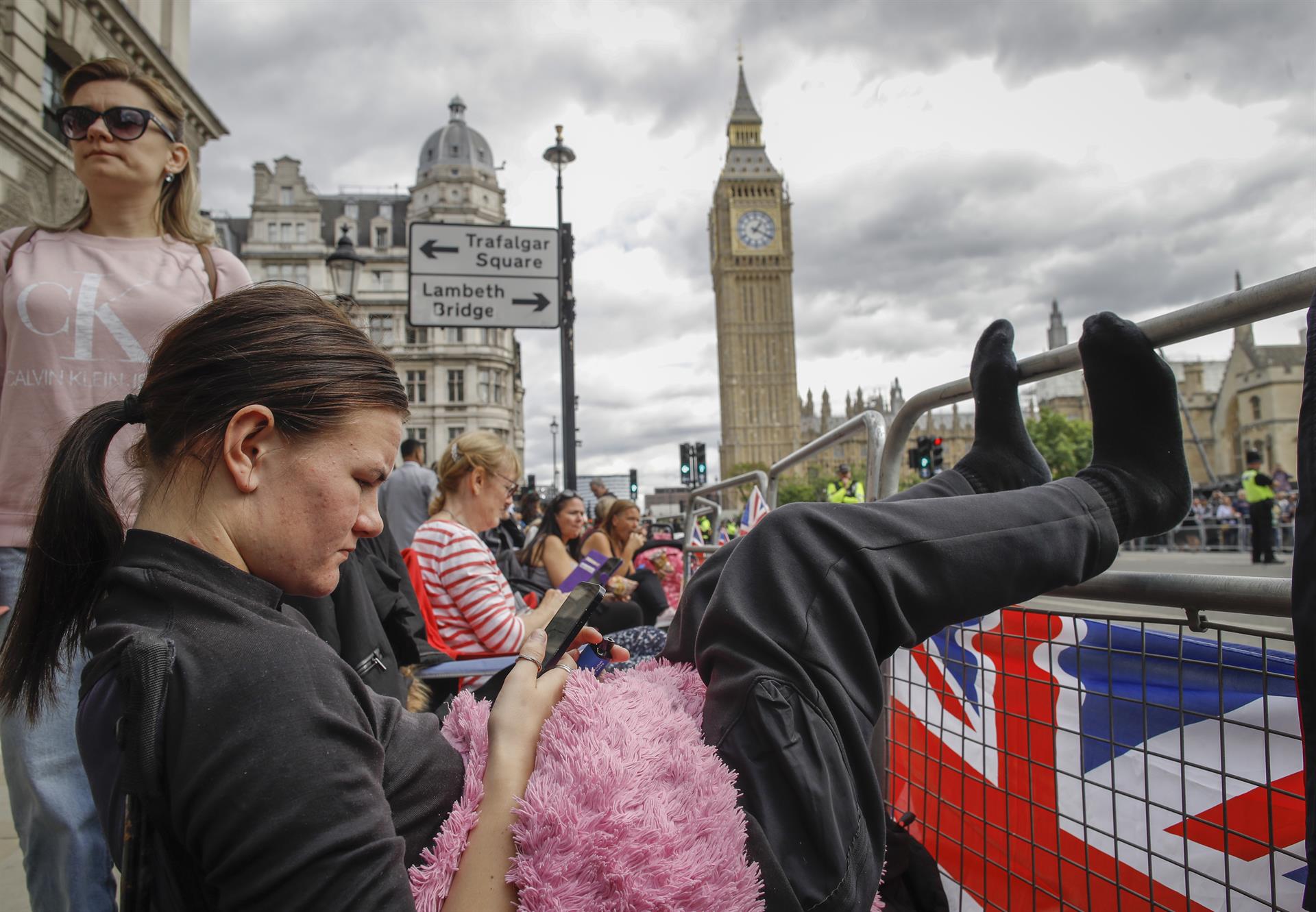 Personas dispuestas a quedarse a dormir en la calle para poder ser testigos del cortejo fúnebre de la difunta reina Isabel II aguardan en una calle de Londres este 18 de septiembre. EFE/EPA/OLIVIER HOSLET
