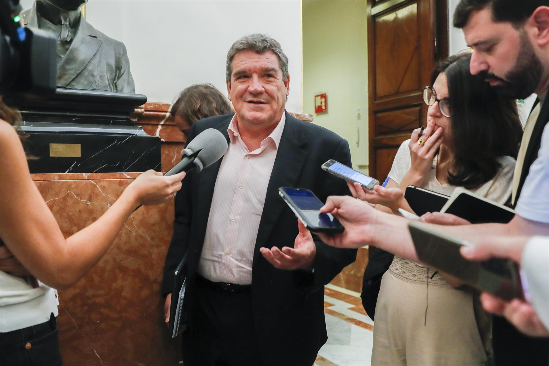 El ministro de Inclusión, Seguridad Social y Migraciones, José Luis Escrivá, se dirige a medios de comunicación en los pasillos del Congreso donde se celebra la sesión de control, este miércoles, en Madrid. EFE/ Juan Carlos Hidalgo
