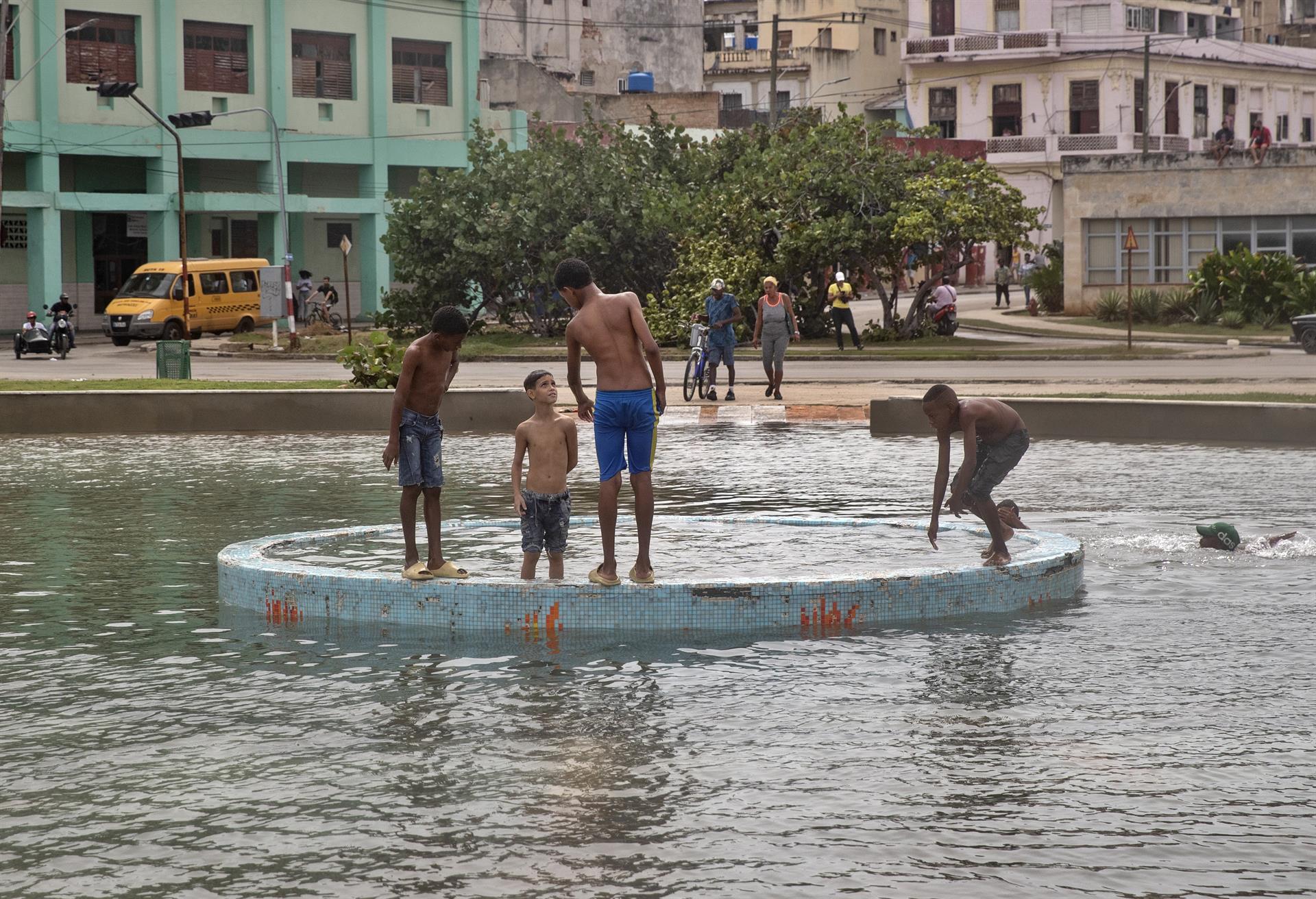 Varios jóvenes se diviertan en el agua tras el paso del huracán Ian, hoy, en La Habana (Cuba). EFE/ Yander Zamora
