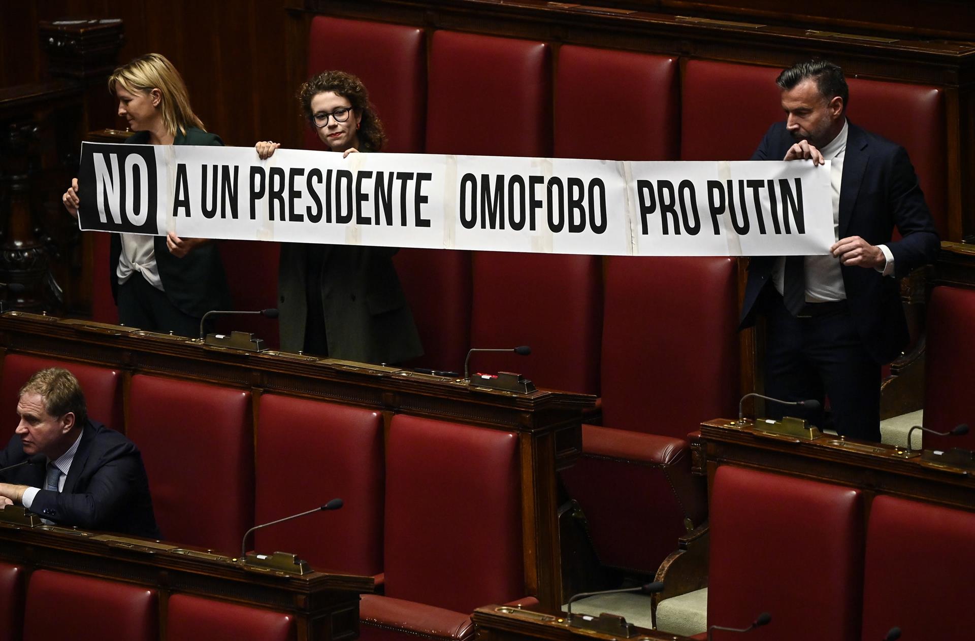 Diputados del Partido Democrático (PD) italiano sostienen una pancarta que dice "no a un presidente homofóbico pro-Putin" durante la elección del presidente de la Cámara de Diputados de Italia. EFE/EPA/RICCARDO ANTIMIANI
